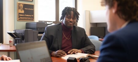 Elijah Joseph and other members of the Applied Portfolio Management Program conduct buy reports in the College of Business Trading Room.