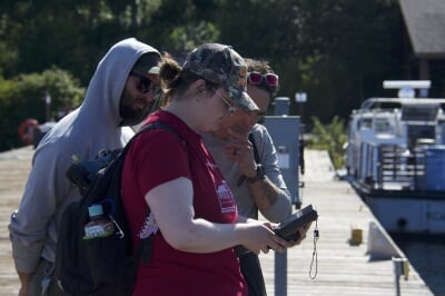 A Michigan Tech student shows National Park Service workers GNSS data collected from a dock at Isle Royale National Park.