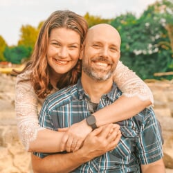 Dannett with her arms around Jerry as they sit on a large rock.