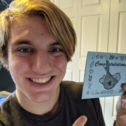 Ethan holding up a 'Congratulations, Future Husky' card with Michigan Tech logo.