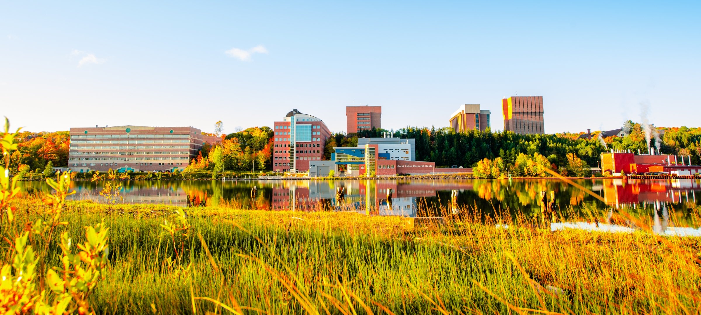 A view of campus from across the waterway in the fall.