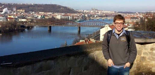 Student posing in front of a large bridge.