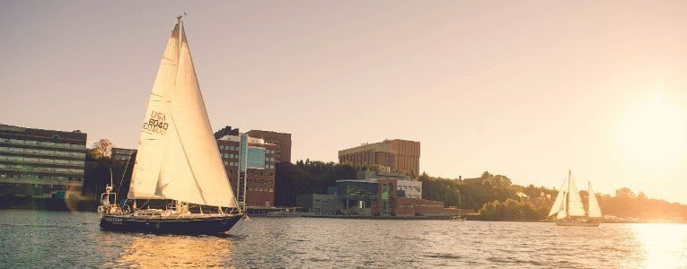 Boats on the canal with Michigan Tech in the background.