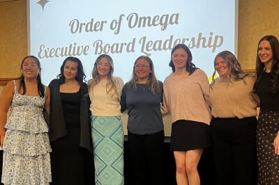 students pose with an award