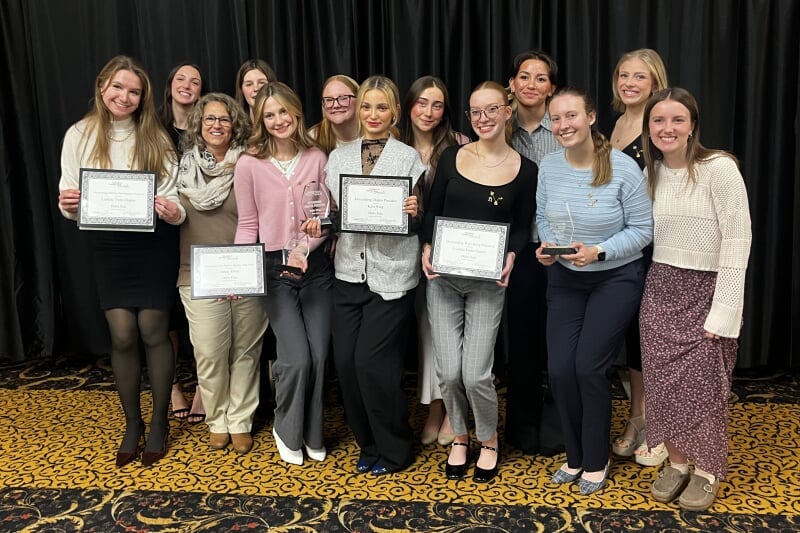 students pose with an award