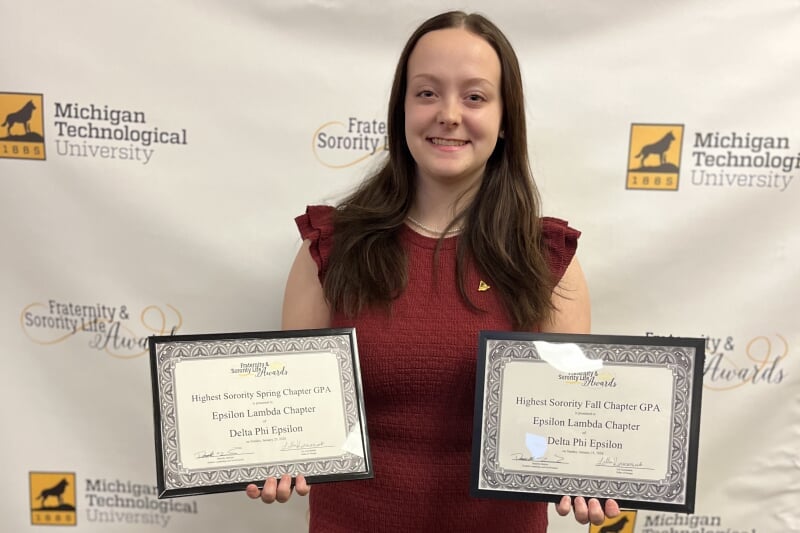 student poses with award