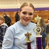 Student holding trophies after a Dance Team competition.