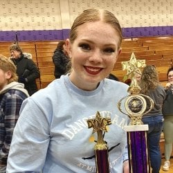 Student holding trophies after a Dance Team competition