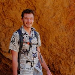 Student standing in front of a rock