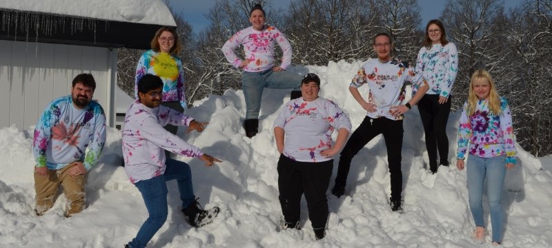 A cluster family climbs a snow bank
