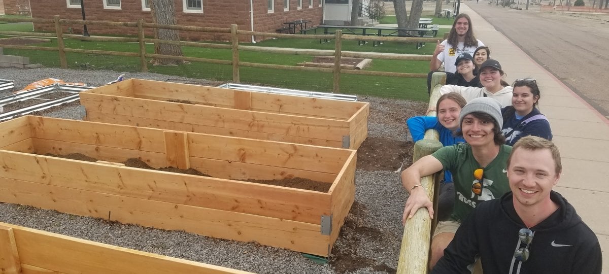 Arizona participants pose with the garden beds they built