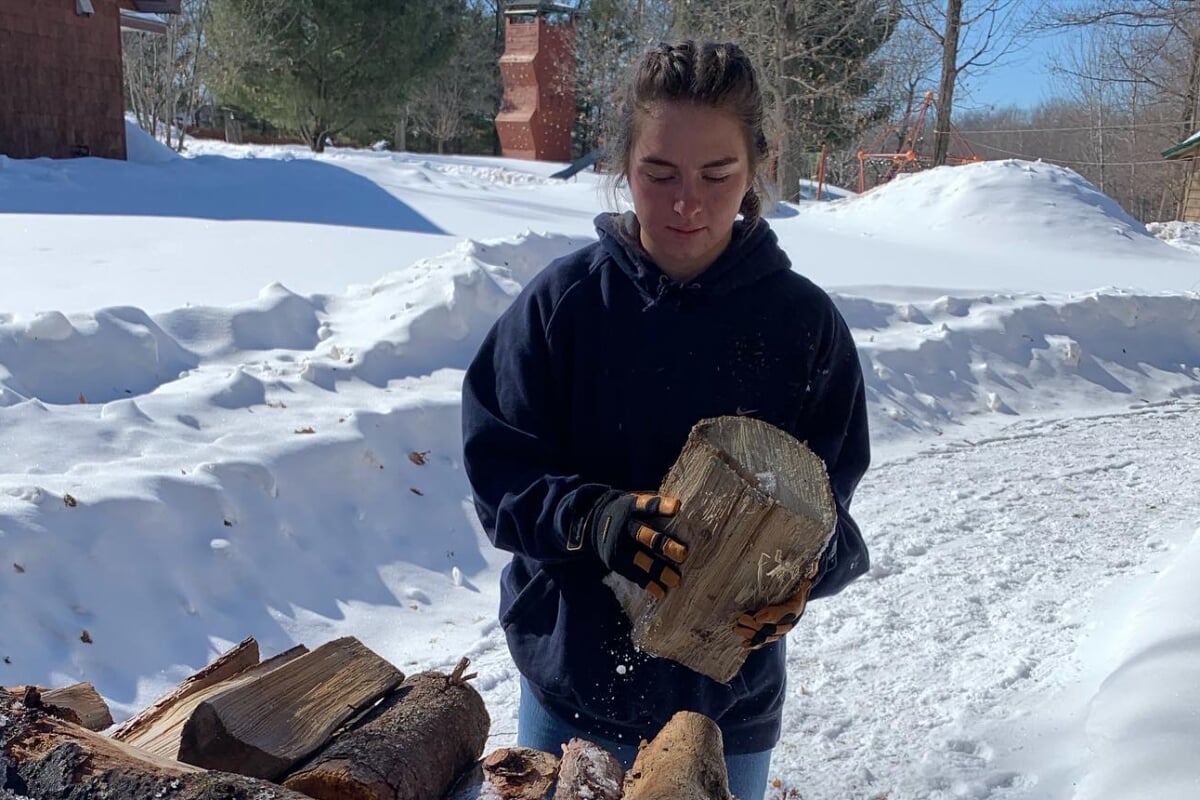 Riley Krause stacks wood at One Heartland