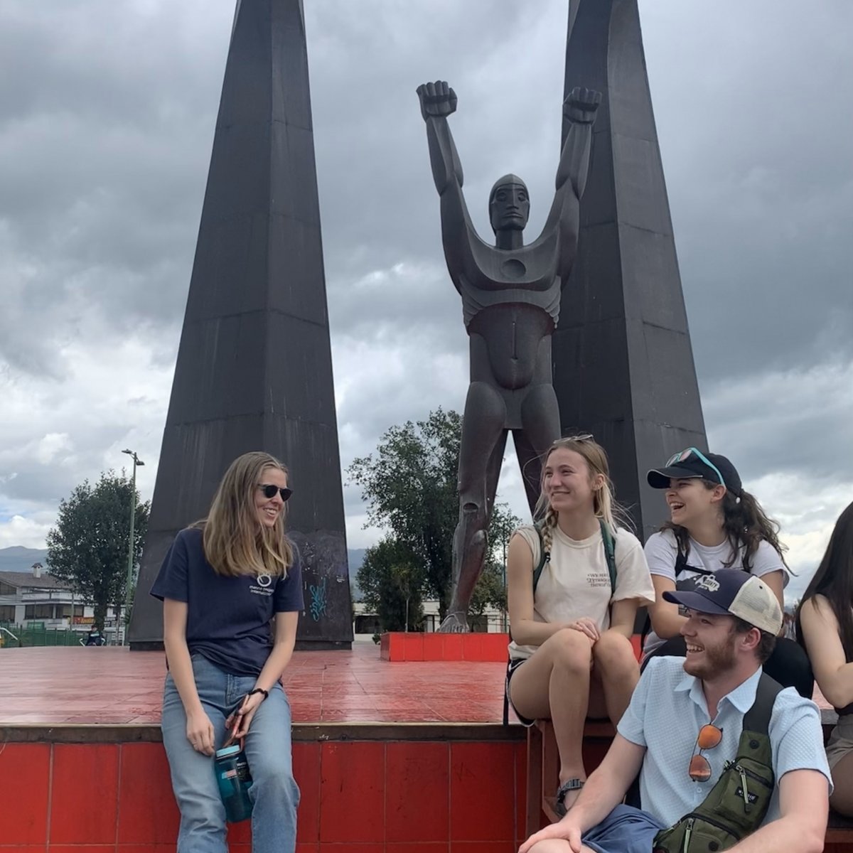 Ecuador trip participants and our site contact, Abby, take a break at a local monument