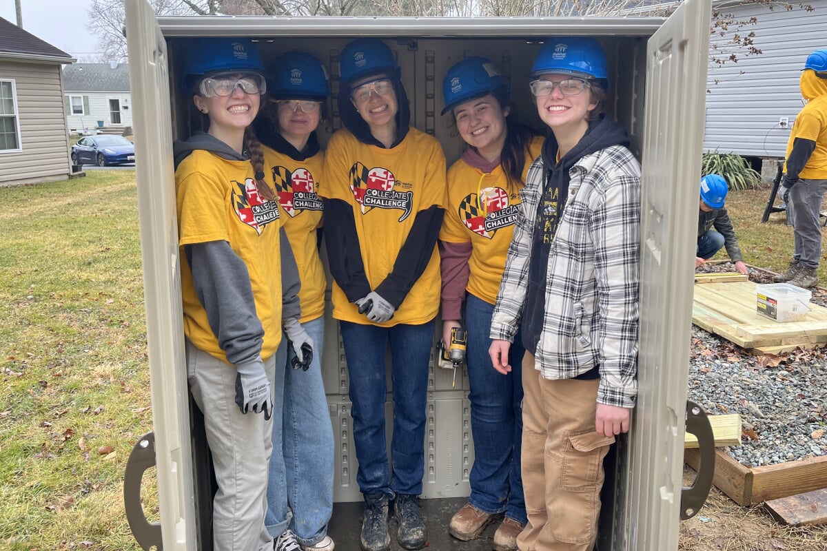 Asia and other students posing in a shed they built during ASB 2026