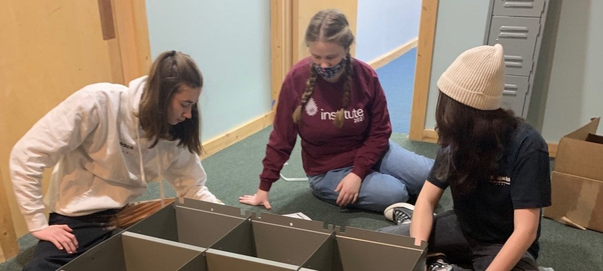 Three participants build lockers for the staff lounge