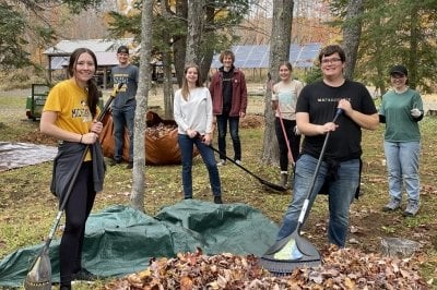 Volunteers stop raking to take a photo