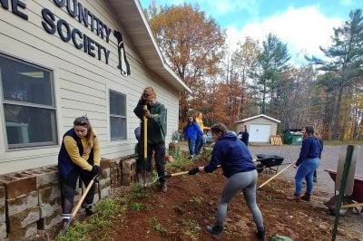 Volunteers shovel gravel at the Copper Country Humane Society
