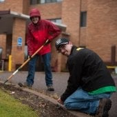 Volunteers rake leaves outside