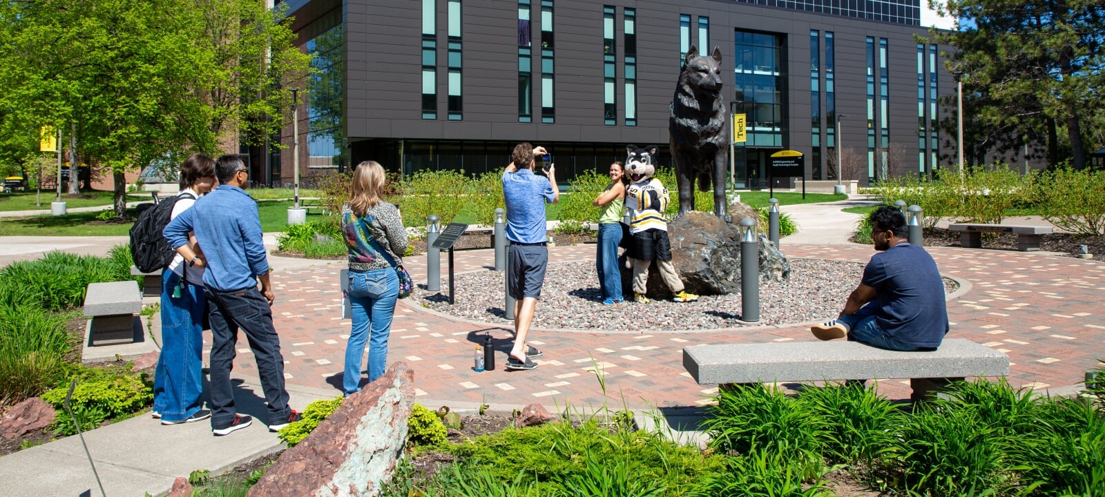 Student and Blizzard post in front of Husky Statue for a Photo.