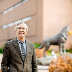 David Shonnard in from of husky statue