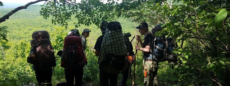 A group of backpackers standing at a scenic overlook