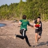 Two young men playing Frisbee on a beach