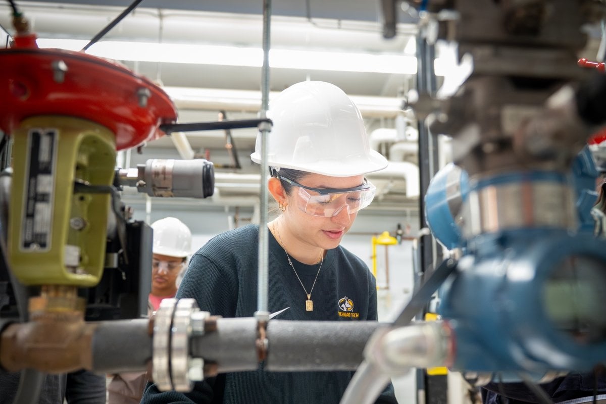 Student wearing a hardhat working in the Unit Operations Lab.