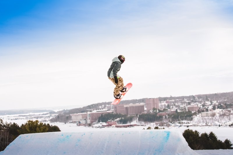 Snowboarder in the air with Michigan Tech in the background.