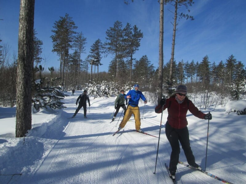 People cross country skiing on a trail.