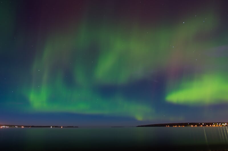Bright green ribbons of the Northern Lights viewed over the Portage Canal in Houghton, MI.