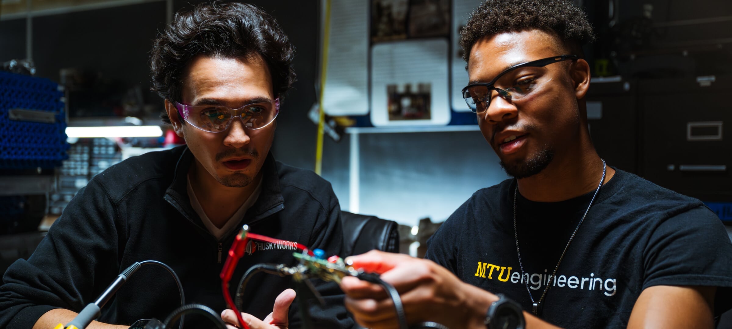 Faculty helping a student with some wiring.