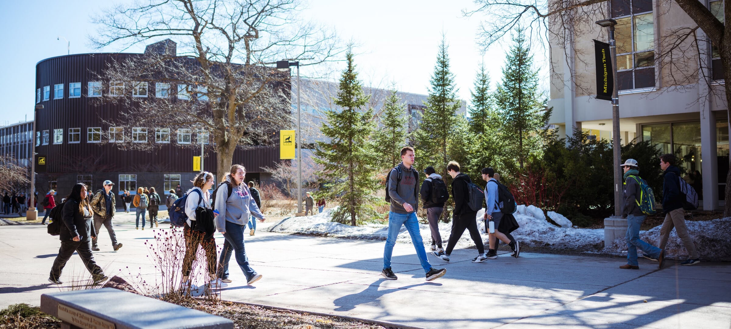 Students walking on campus near Rekhi Hall and the Library.