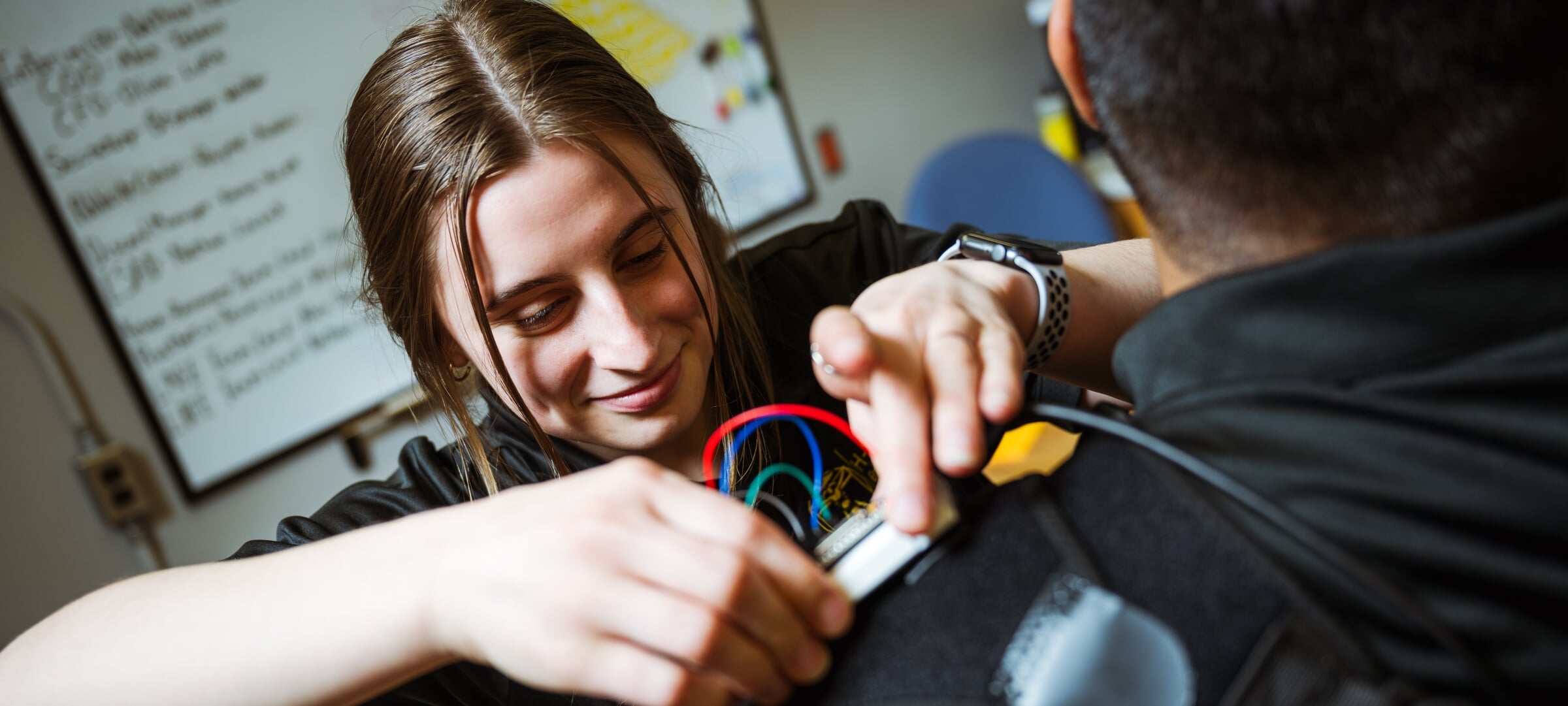 Student working on electrical equipment with wires.