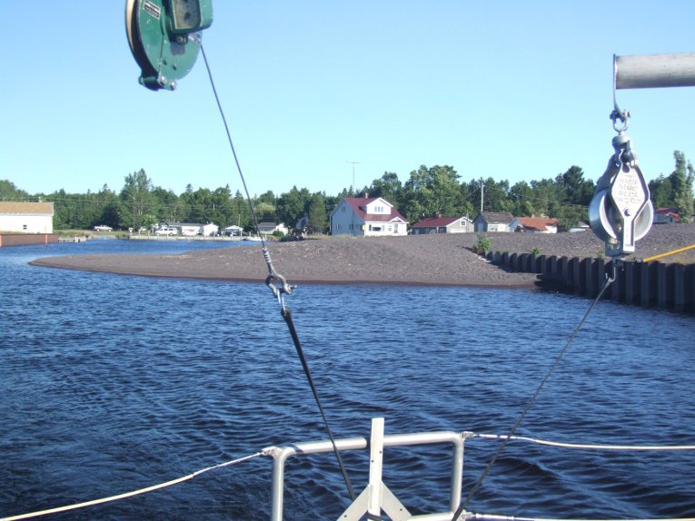 A fan of black stamp sands in the harbor at Grand Traverse Bay 