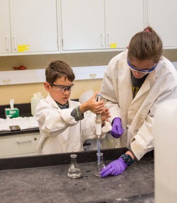 Lewis learns to use a pipette by practicing with water. 