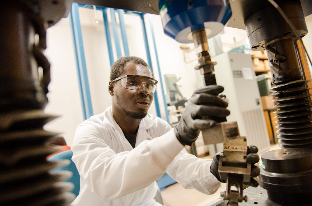 Munkaila Musah, a doctoral student in forest molecular genetics and biotechnology, adjusts the cross-laminated timbers unit block for internal bonding and shear test at the pilot plant room in the School of Forest Resources and Environmental Science.