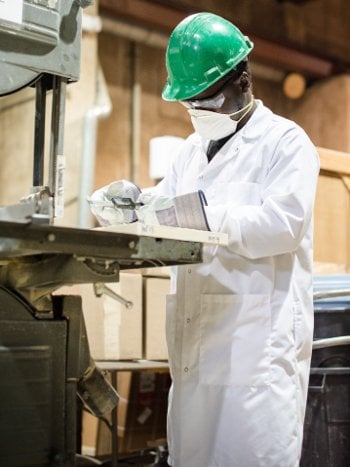 Munkaila Musah measures a piece of wood.