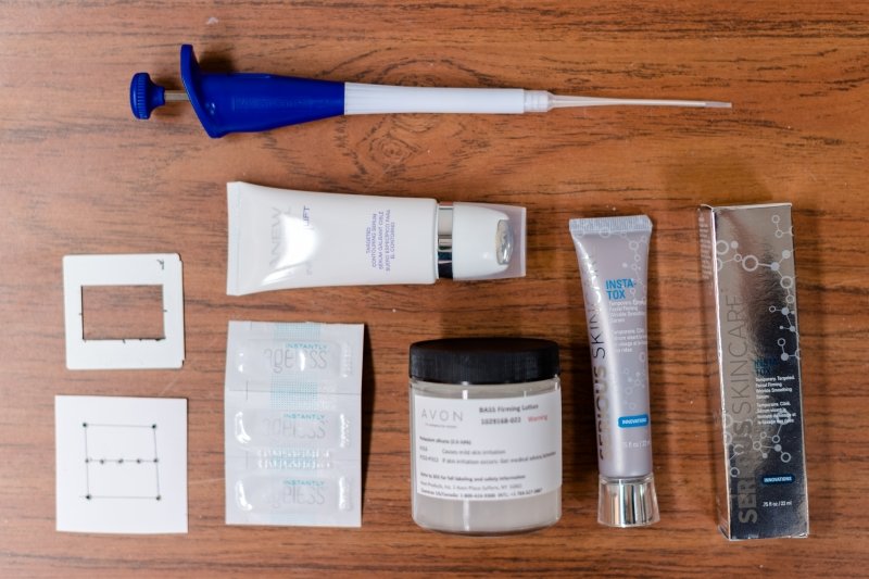 Avon products line up neatly next to a high-precision pipette
