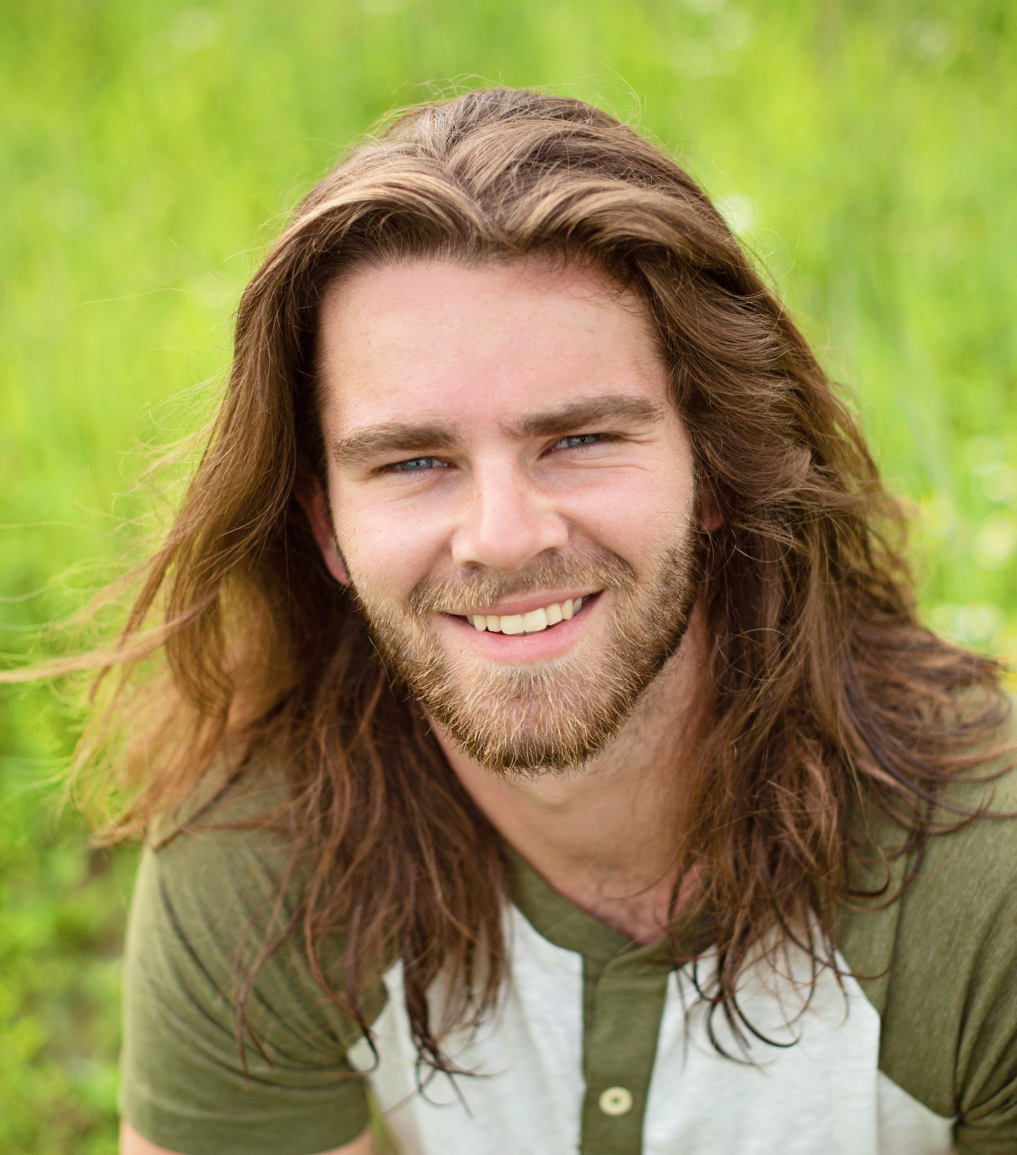 young man with long hair in a long sleeve shirt