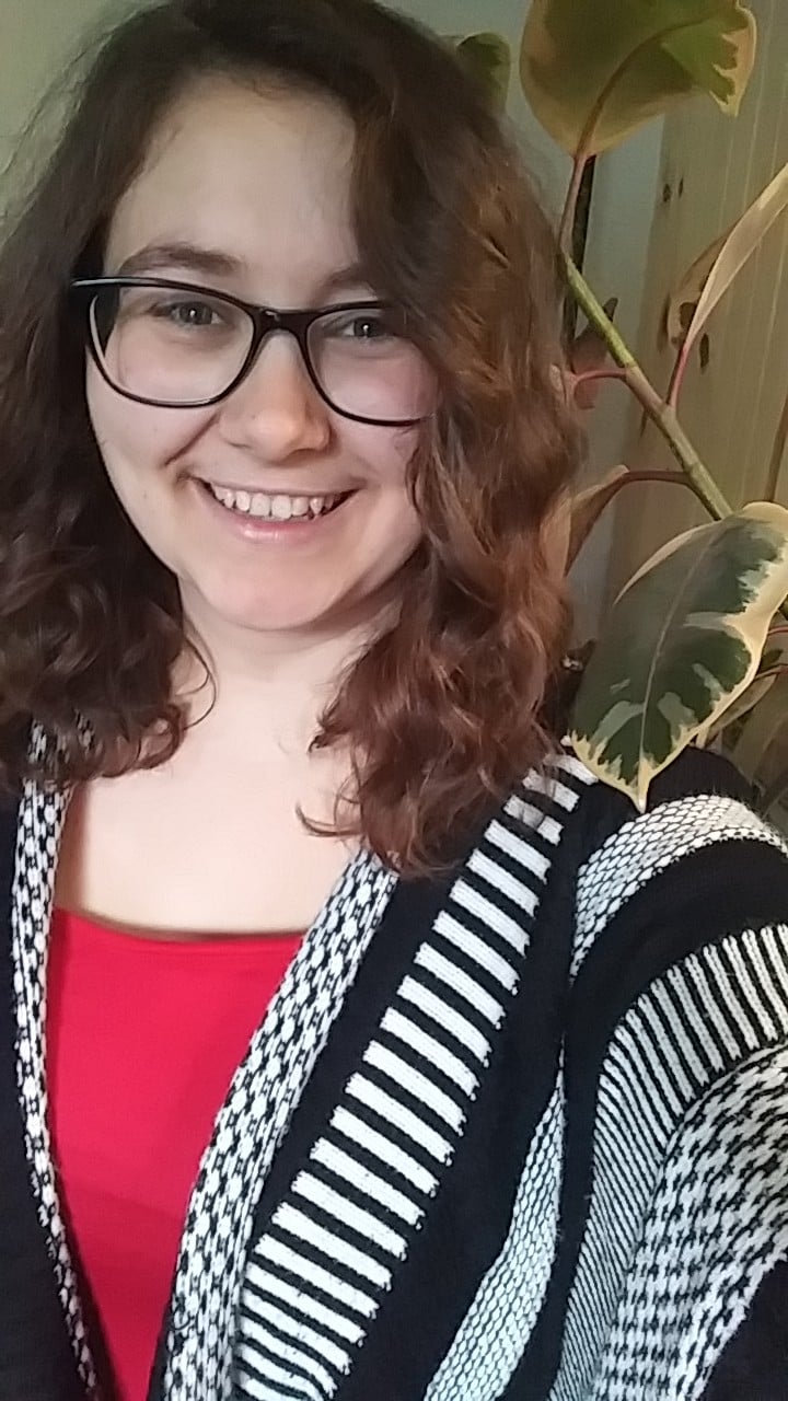 young woman with curly hair and glasses