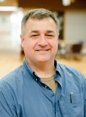 smiling man in a denim work shirt