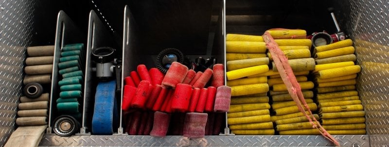 brightly colored fire hoses folded in the back of a firetruck