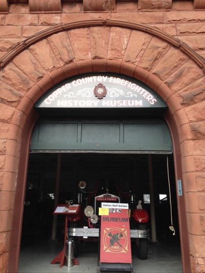 sandstone archway with antique firefighter equipment in the doorway