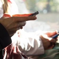 hands typing on cell phones with blurred background