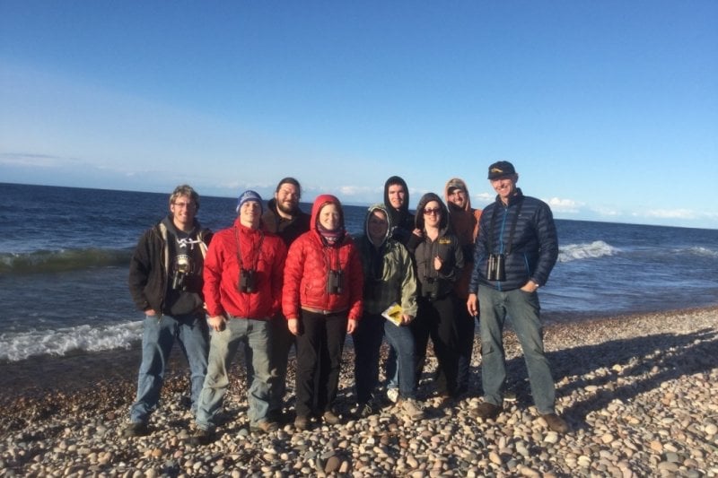 groups of people standing on a rocky beach