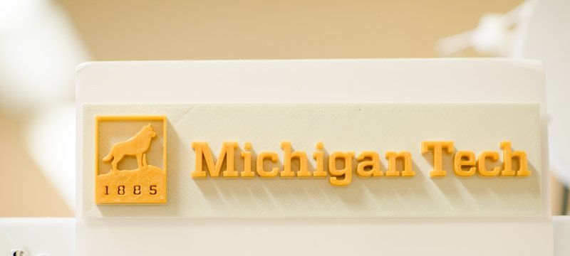 A 3D printed image of the Michigan Tech logo 1885 with a Husky on a rock and the words Michigan Tech