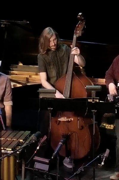 A student at michigan tech plays stand up bass in a concert onstage