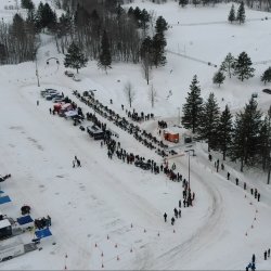 An overview aerial of the Blizzard Baja starting line and staging area for Michigan Tech's Winter Invitational outside near the student development complex.