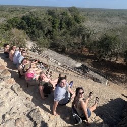 Students from Michigan Tech sit on the steps of Mayan ruins in the Yucatan.