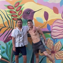 Two Tech students in front of a hummingbird mural celebrating study abroad friendships.
